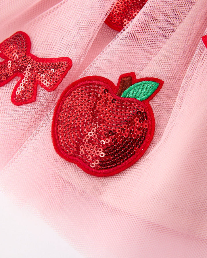 Sequined apple patch on a pink fabric background