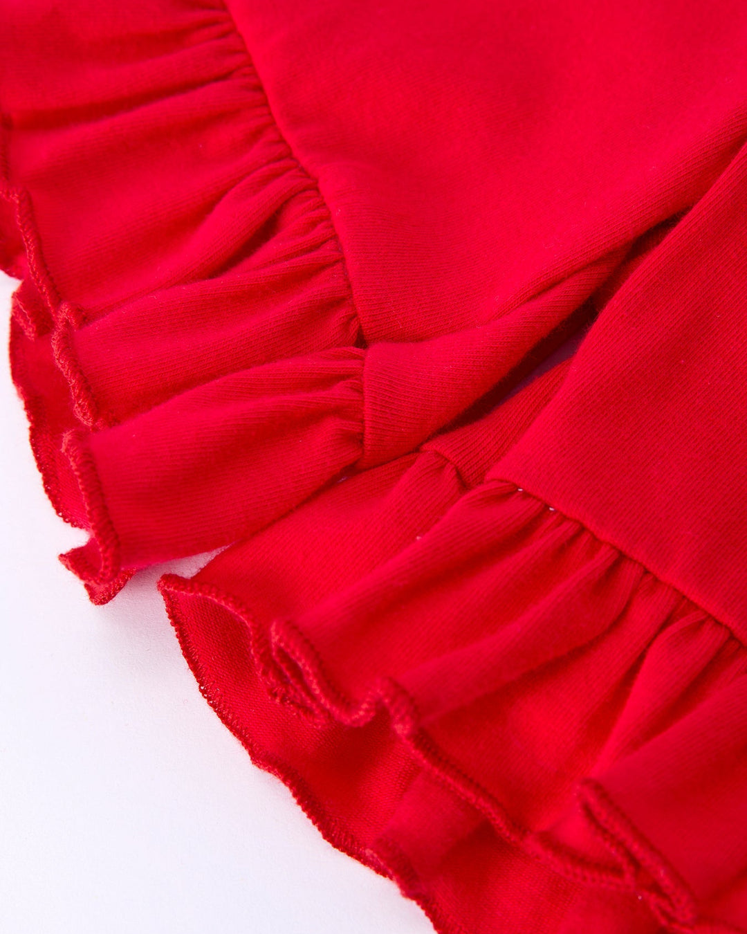 Close-up of red fabric with ruffled edge on a white background