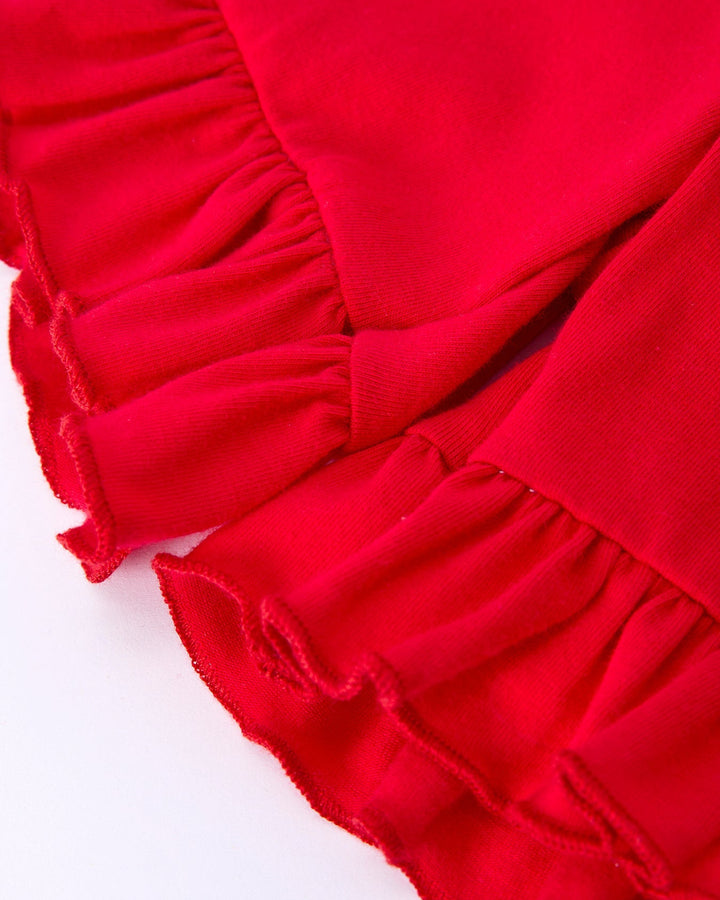 Close-up of red fabric with ruffled edge on a white background