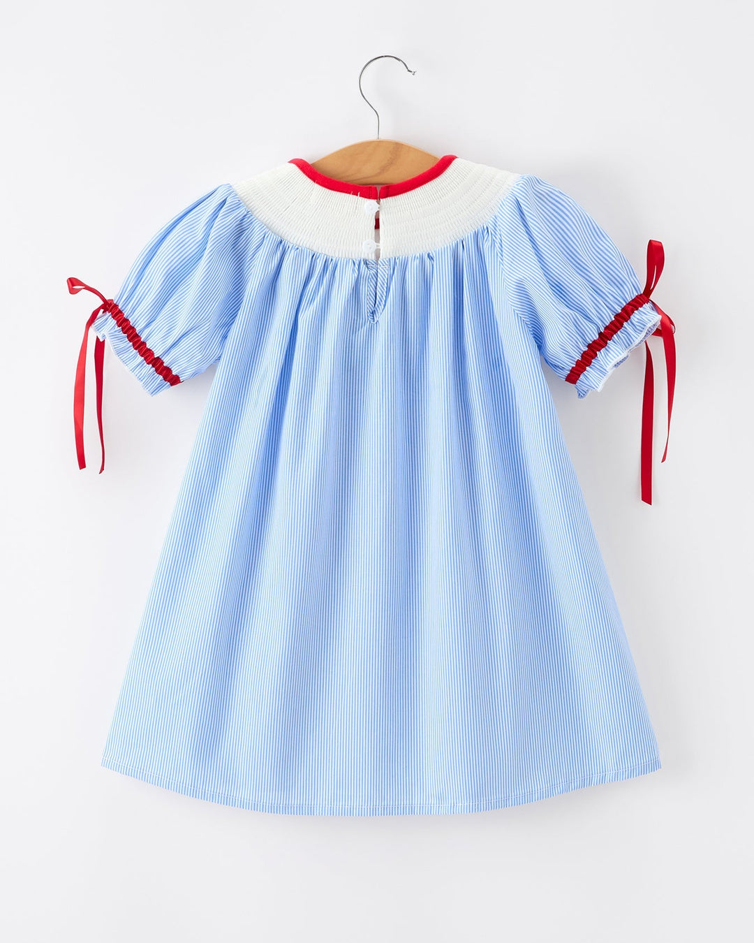 Light blue dress with red accents on a hanger against a white background