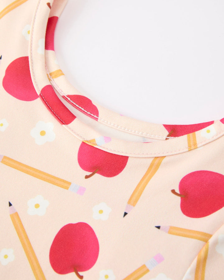 Dress with apple and pencil pattern on a light pink background