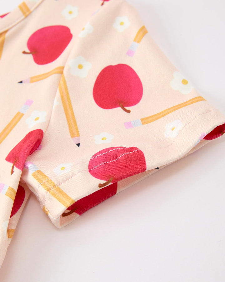 Fabric with red apple and yellow pencil pattern on a light background