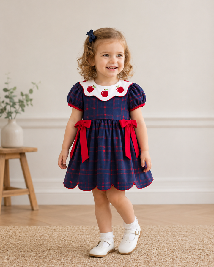 Young girl in navy back to school dress with red side bows