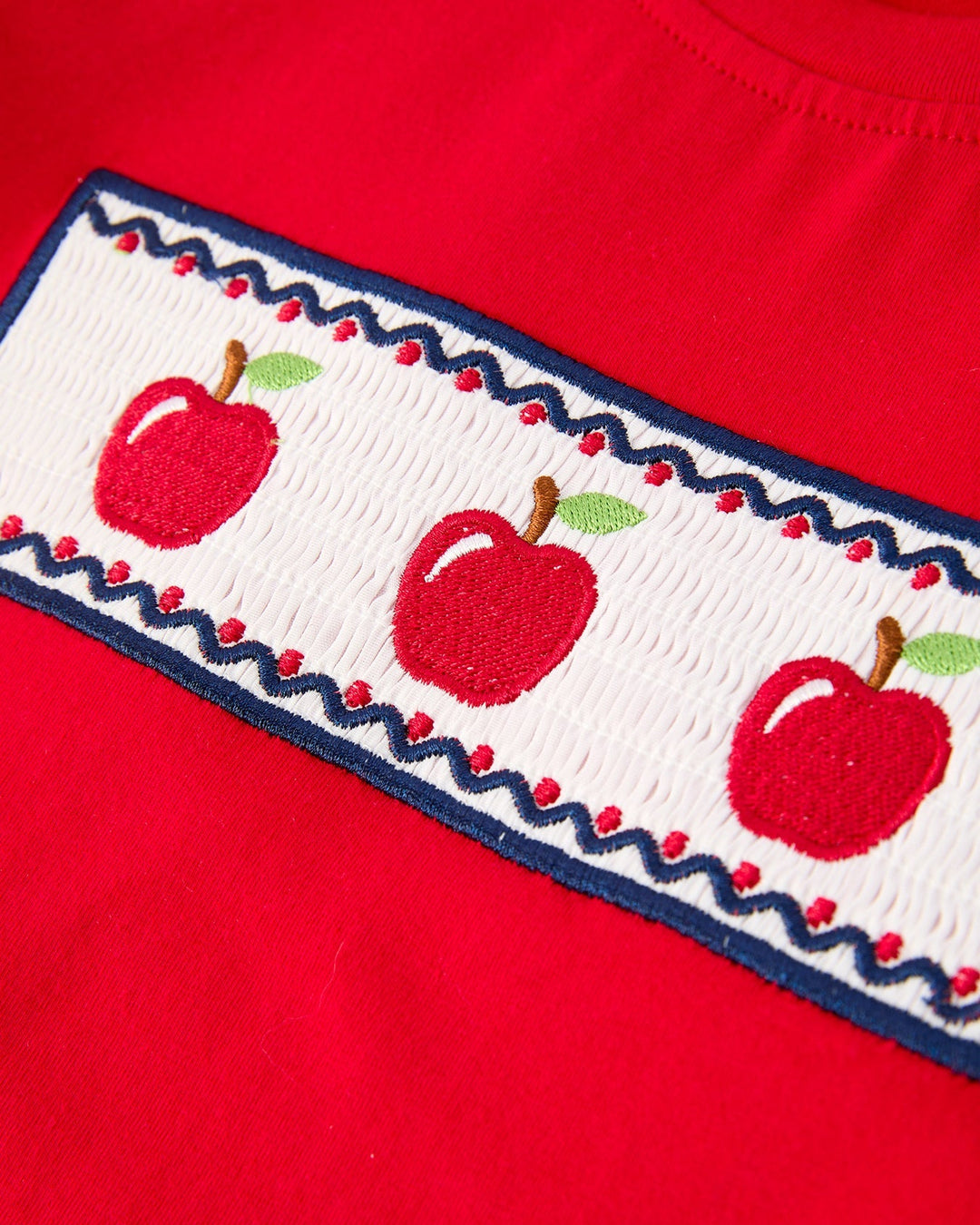 Red shirt with embroidered apples on a white background