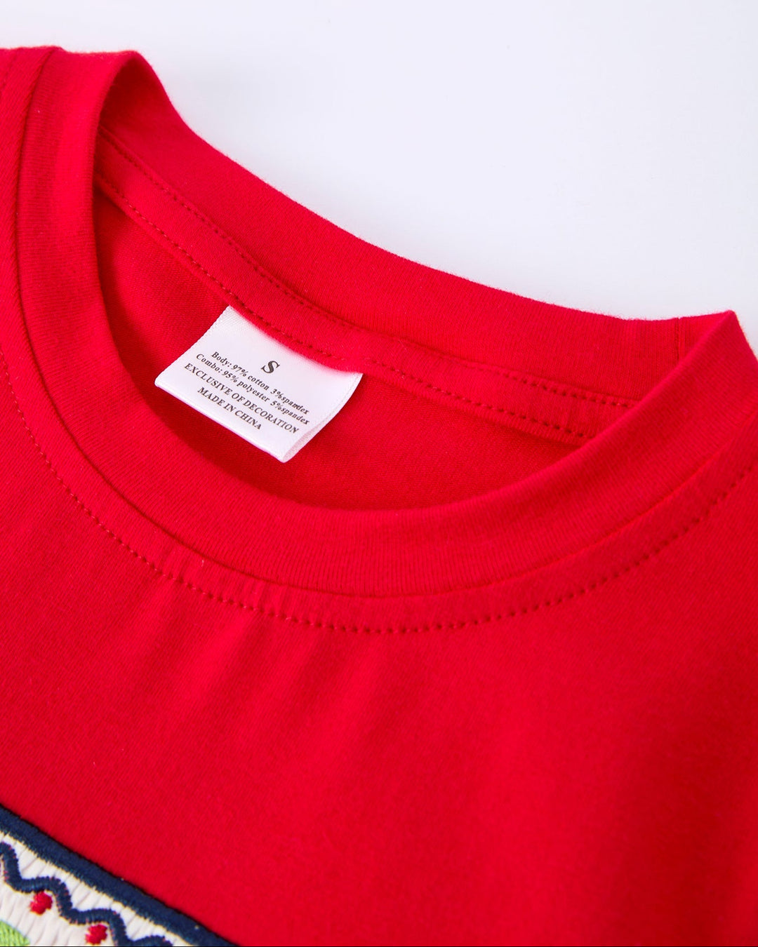 Close-up of a red shirt with a label on a white background