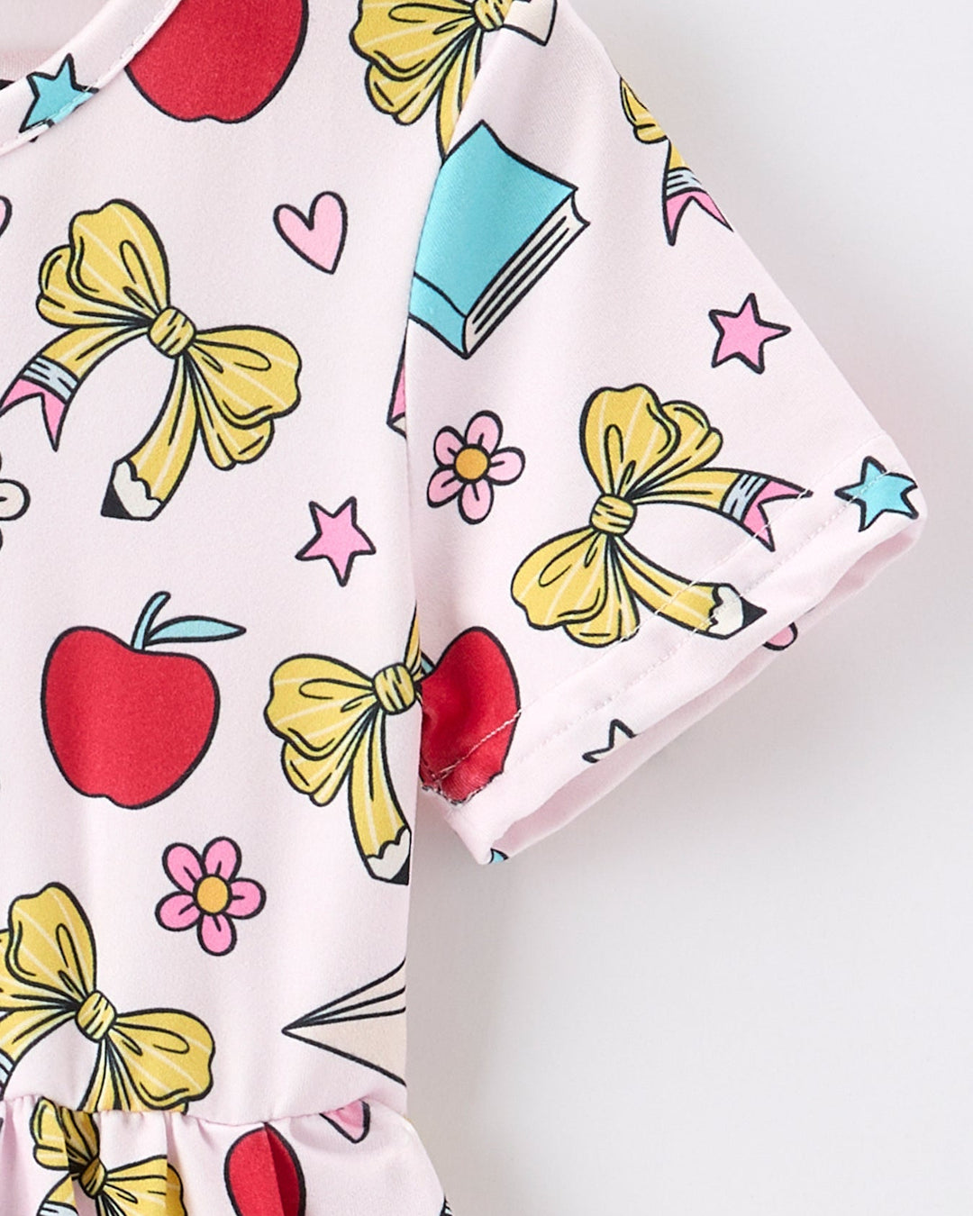 Colorful fabric with bows, apples, and stars on a white background