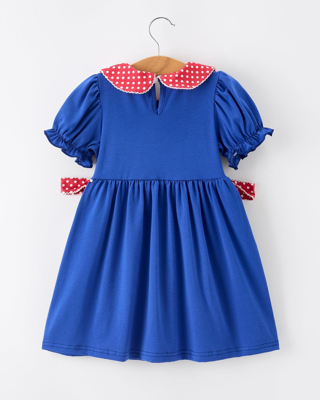 Blue dress with red polka dot collar on a white background