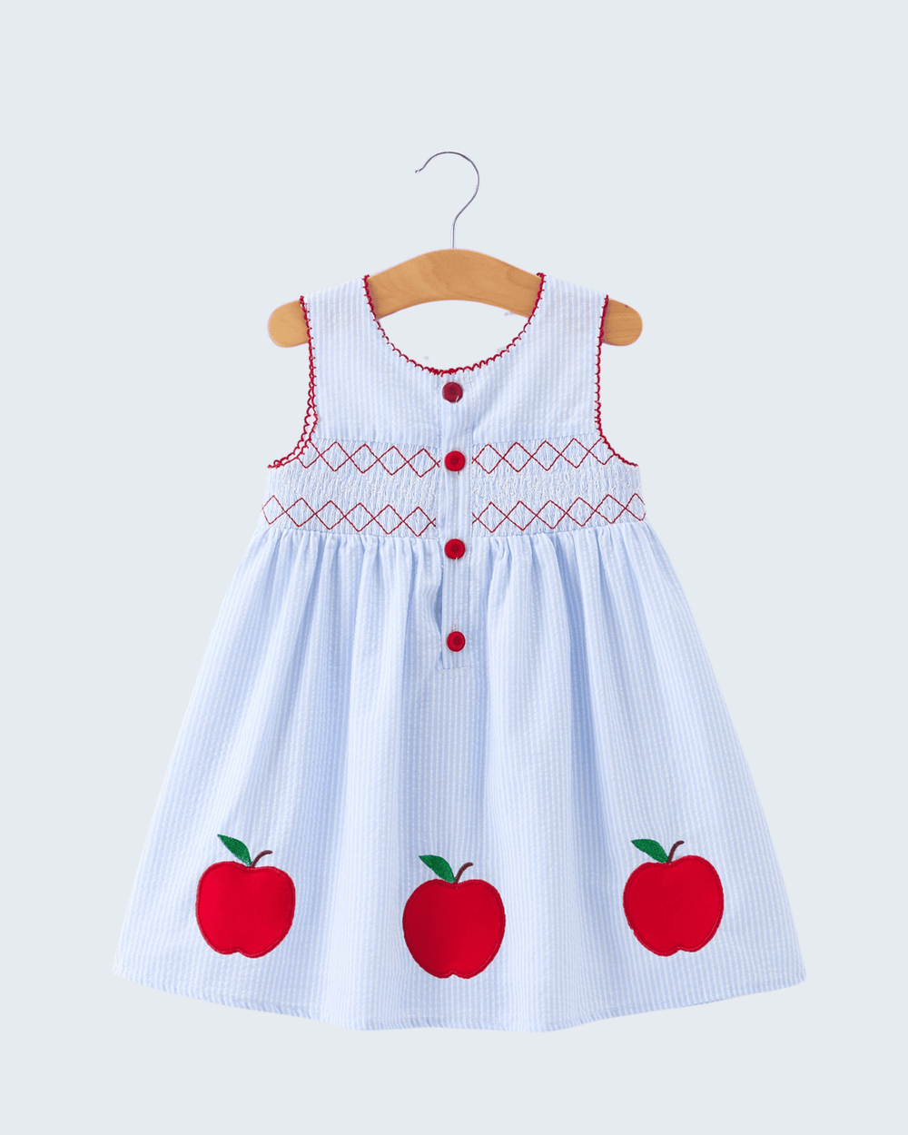 Children's dress with red apples on a white background