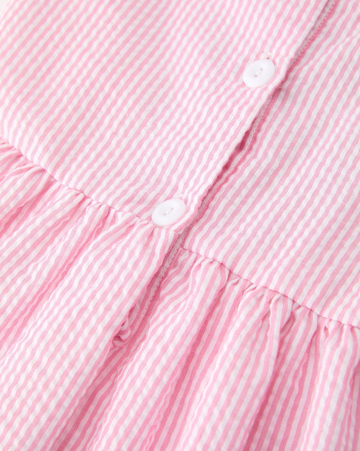 Close-up of a pink and white striped dress with buttons.