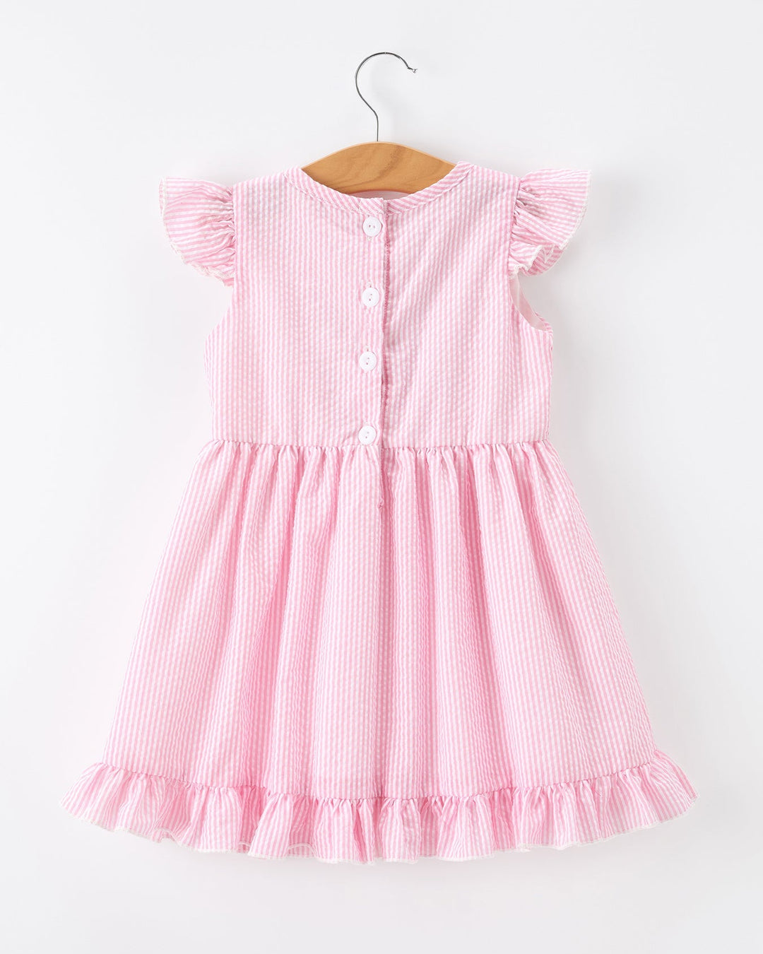 Pink striped dress on a hanger against a white background
