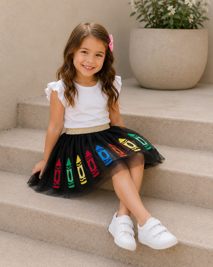 Young girl sitting on steps wearing Back To School Crayon Applique Tulle Skirt