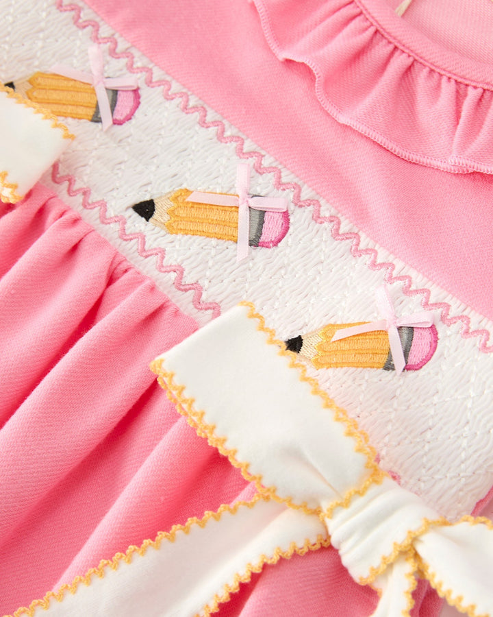 Close-up of a pink dress with pencil pattern and ruffled details