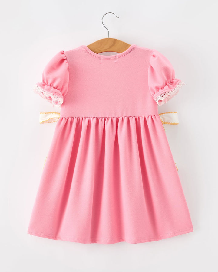 Pink dress on a hanger against a white background