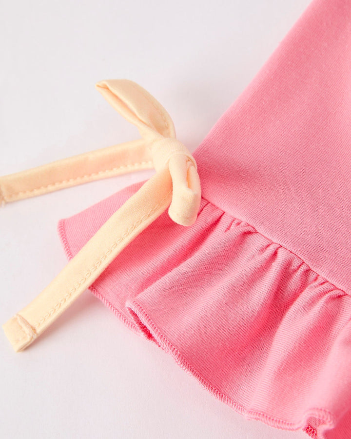 Pink dress with yellow straps on a light gray background
