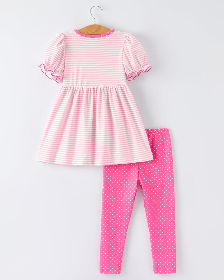 Pink and white striped dress and pink polka dot leggings on a hanger against a white background