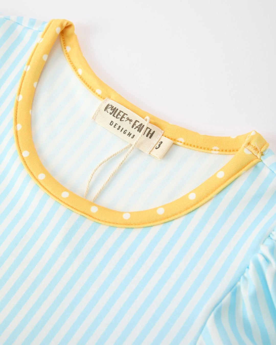 Close-up of a yellow polka dot collar on a blue and white striped shirt with &