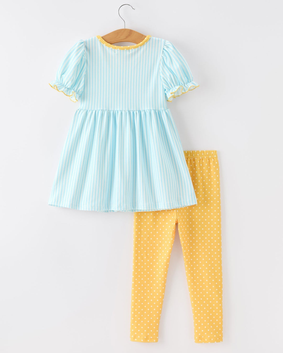 Light blue dress with yellow trim and matching yellow polka dot leggings on a white background