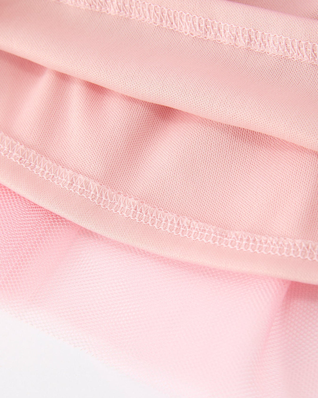 Close-up of pink fabric with a focus on texture and stitching.