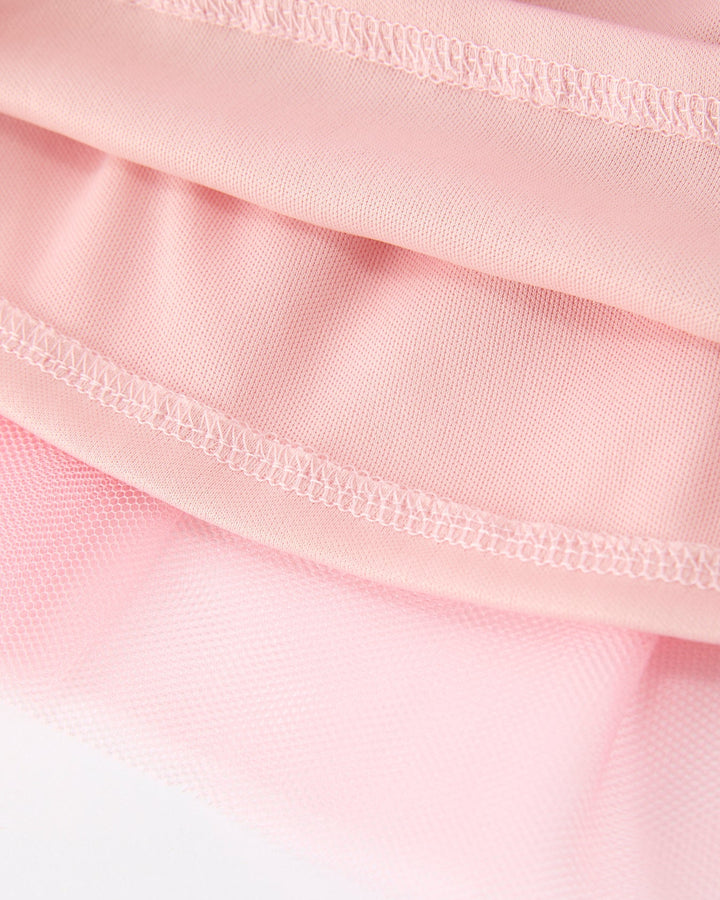 Close-up of pink fabric with a focus on texture and stitching.