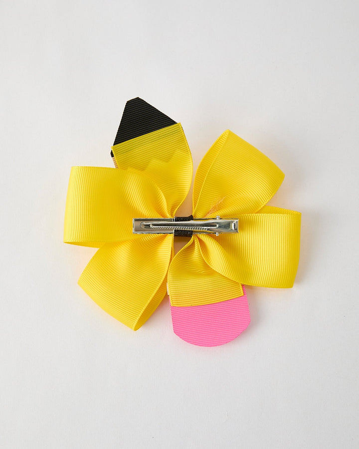 Colorful hair bow with a clip on a light gray background