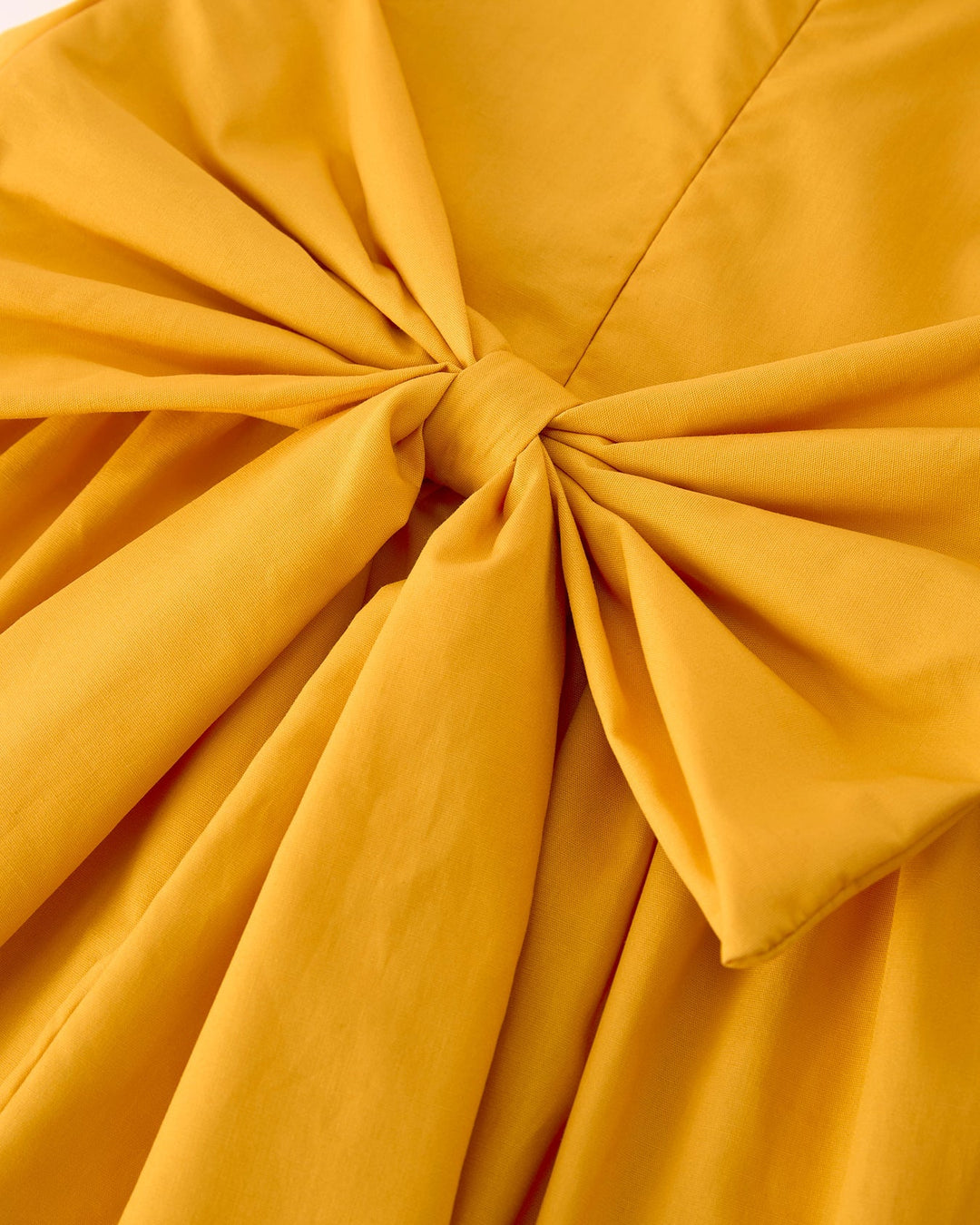 Close-up of a mustard yellow fabric with a knot