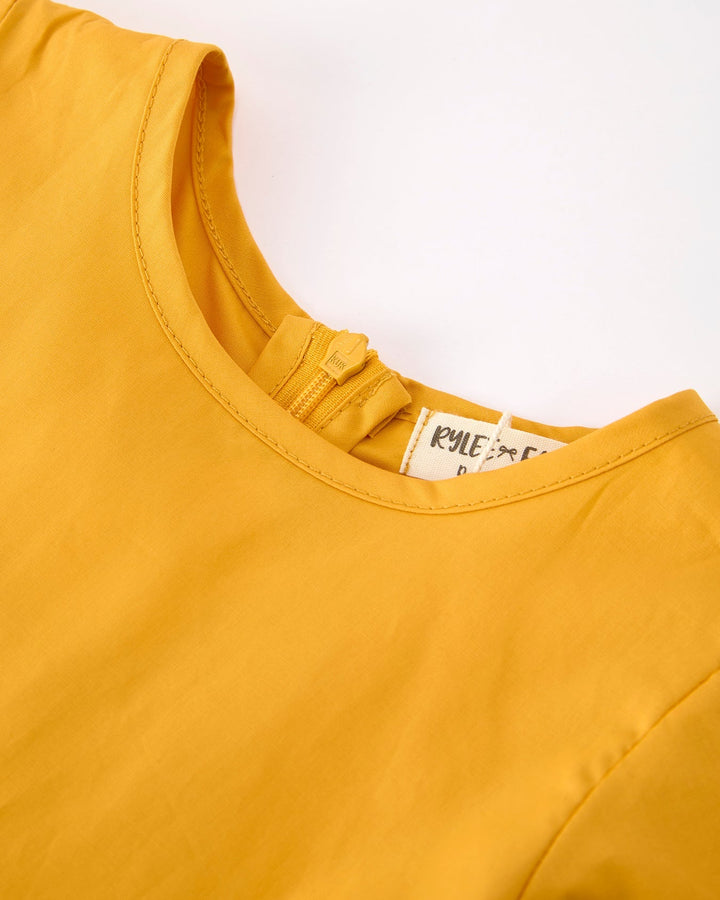 Yellow top with a brand label on a white background