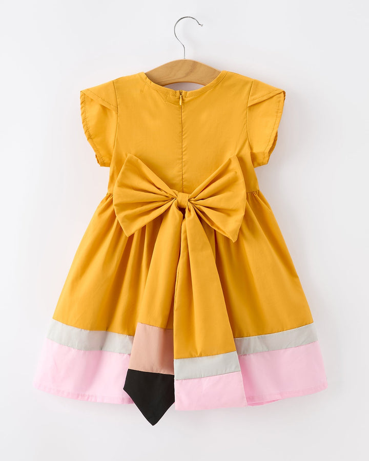 Yellow dress with a large bow on a hanger against a white background
