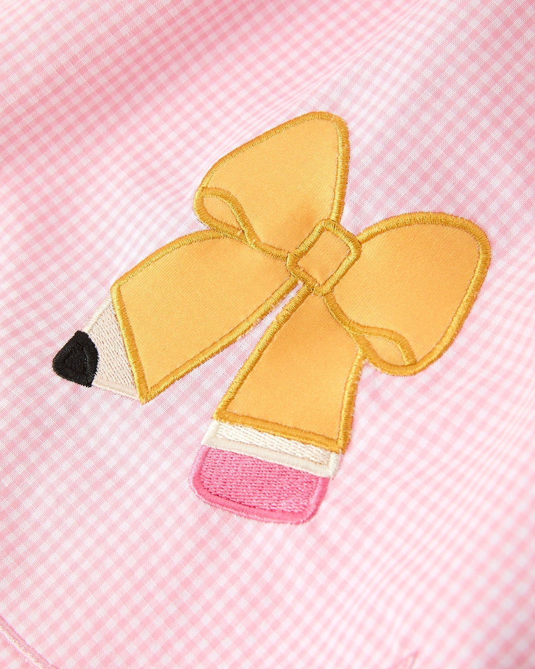 Yellow bow with a pencil design on a pink checkered background