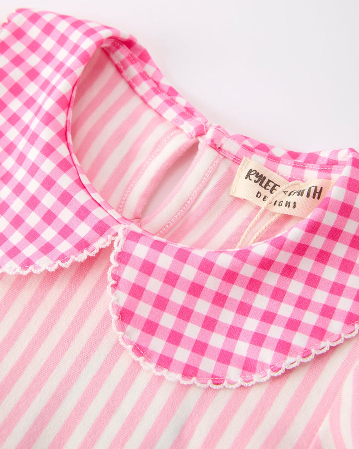 Pink gingham girls dress with a visible brand label on a white background