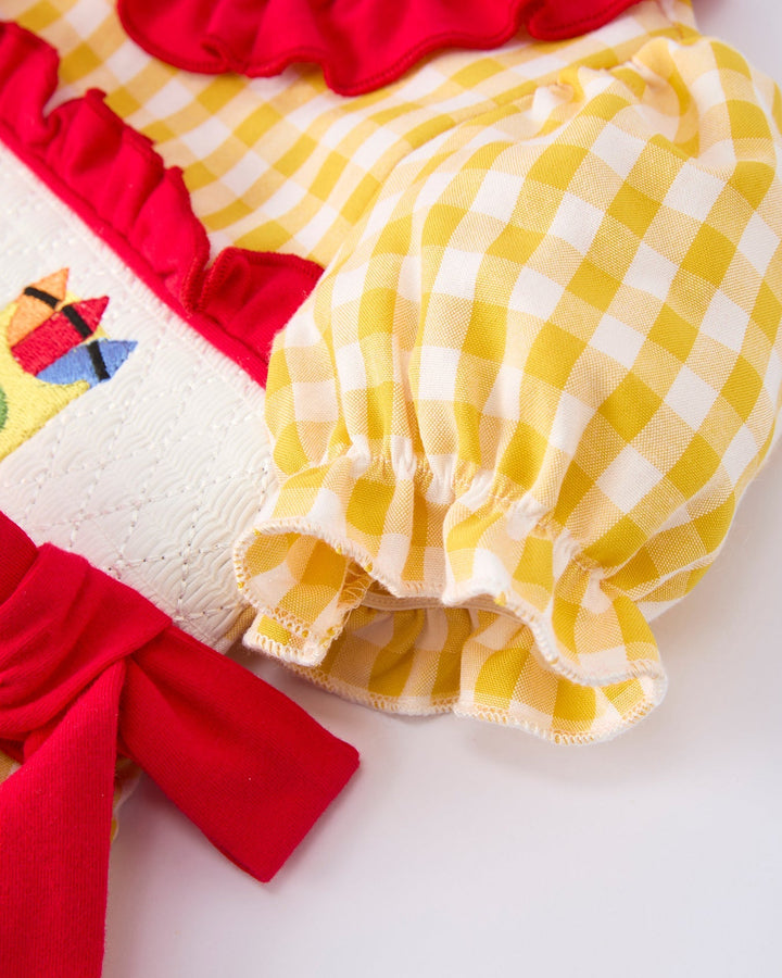 Close-up of a yellow checkered fabric with red accents on a white background