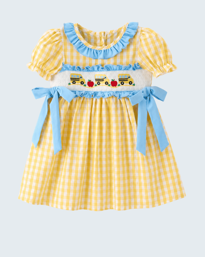 Yellow checkered dress with blue ruffles and embroidered details on a light gray background