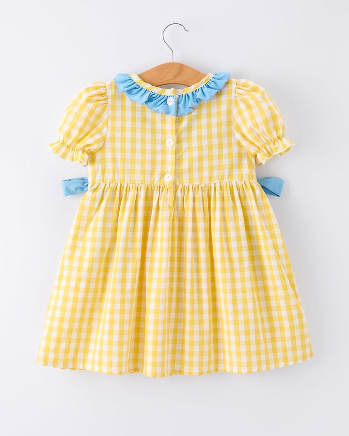 Yellow checkered dress with blue ruffled collar on a white background