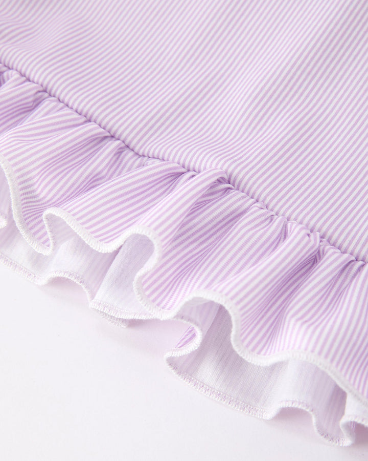 Close-up of a purple fabric with ruffled edge on a white background