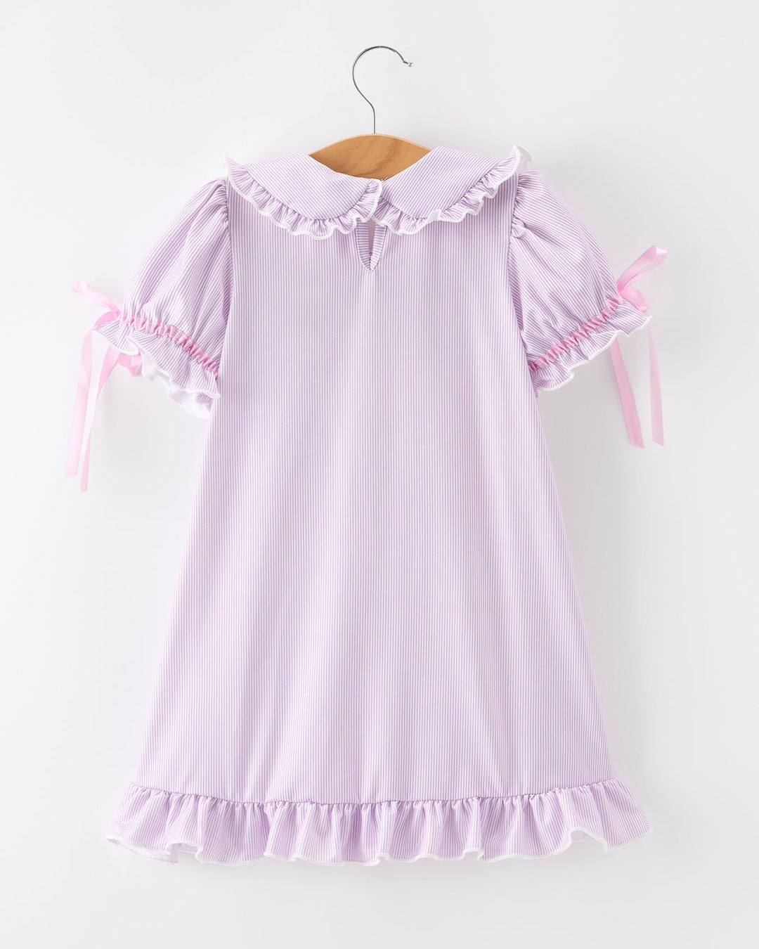 Pink dress with ruffled details on a white background