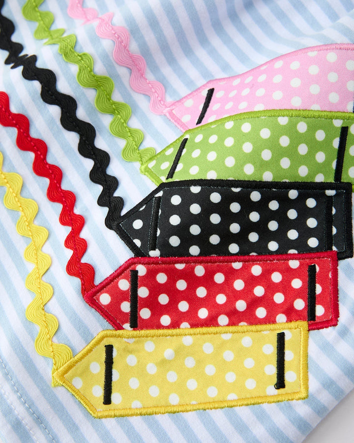 Colorful fabric strips with polka dots and zigzag patterns on a striped background