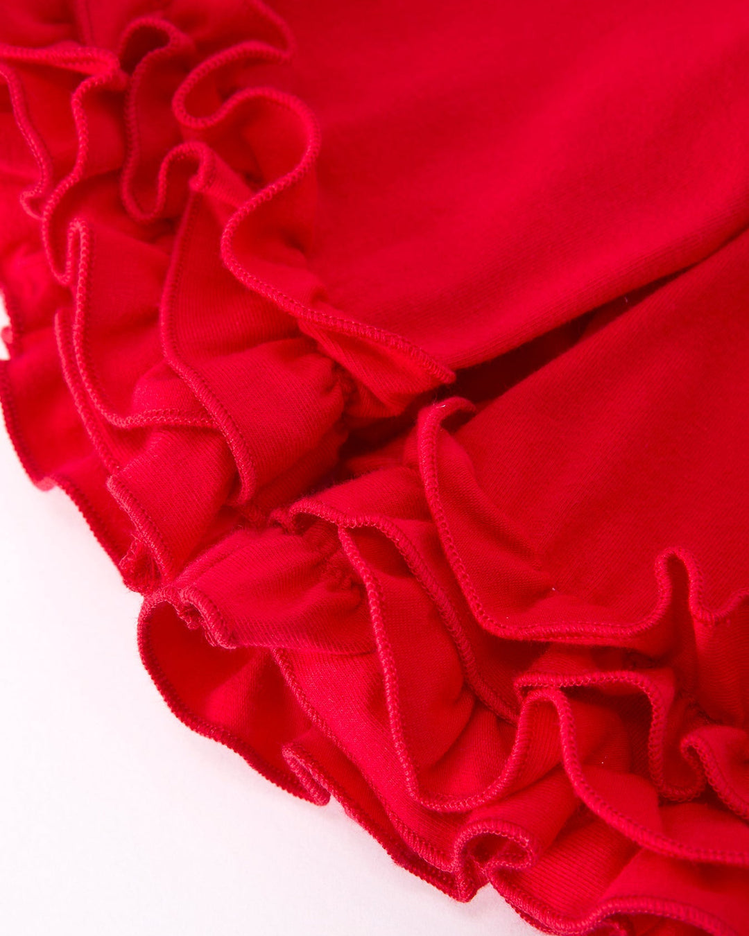 Close-up of red ruffled fabric on a white background