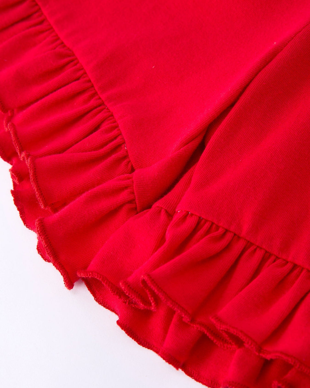 Close-up of red fabric with ruffled edge on a white background