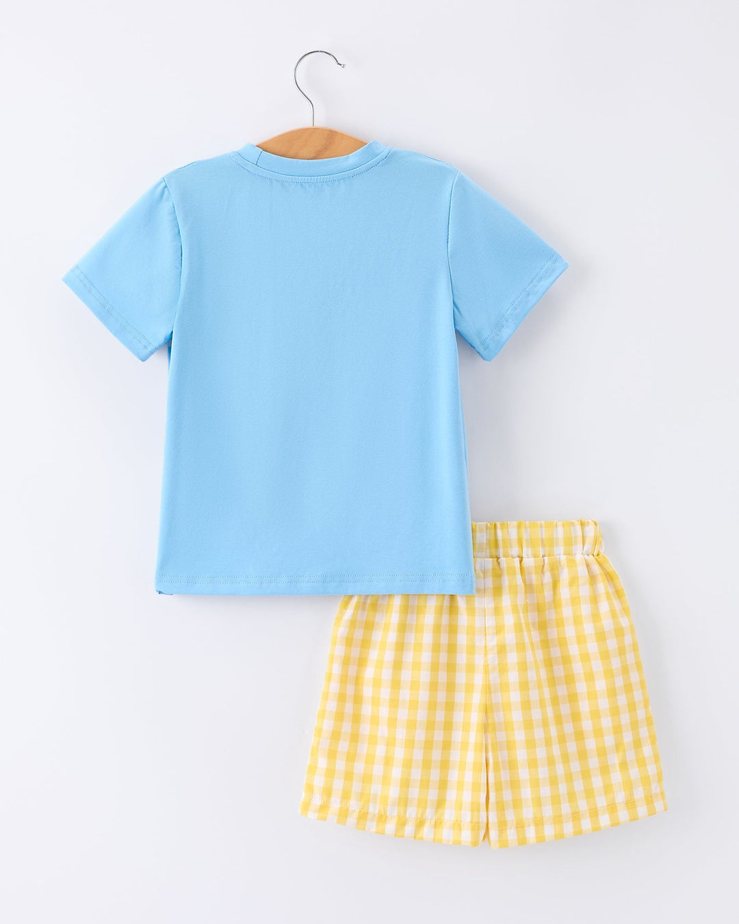 Light blue t-shirt and yellow checkered shorts on a white background