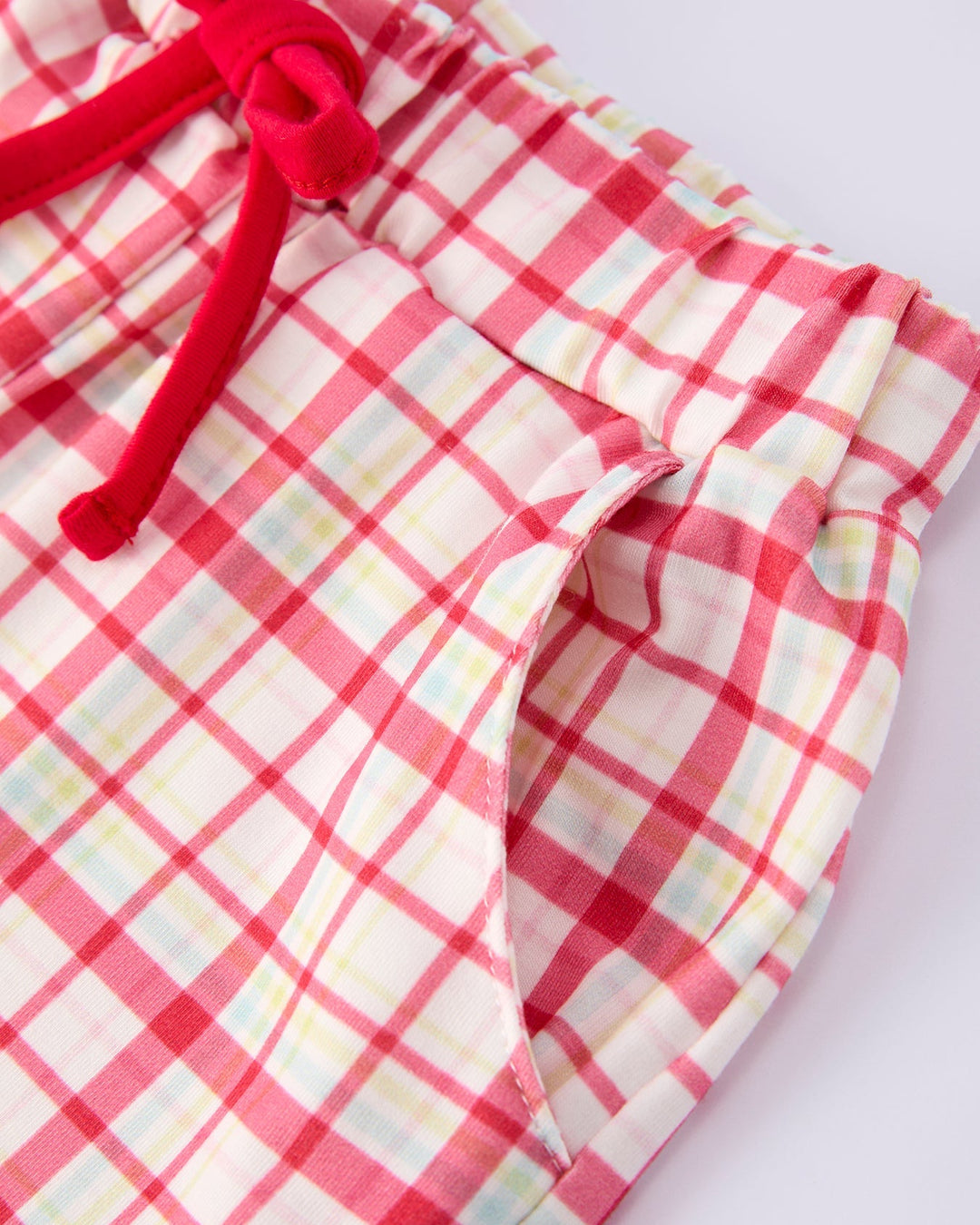 Red and white checkered shorts with a red tie on a light background