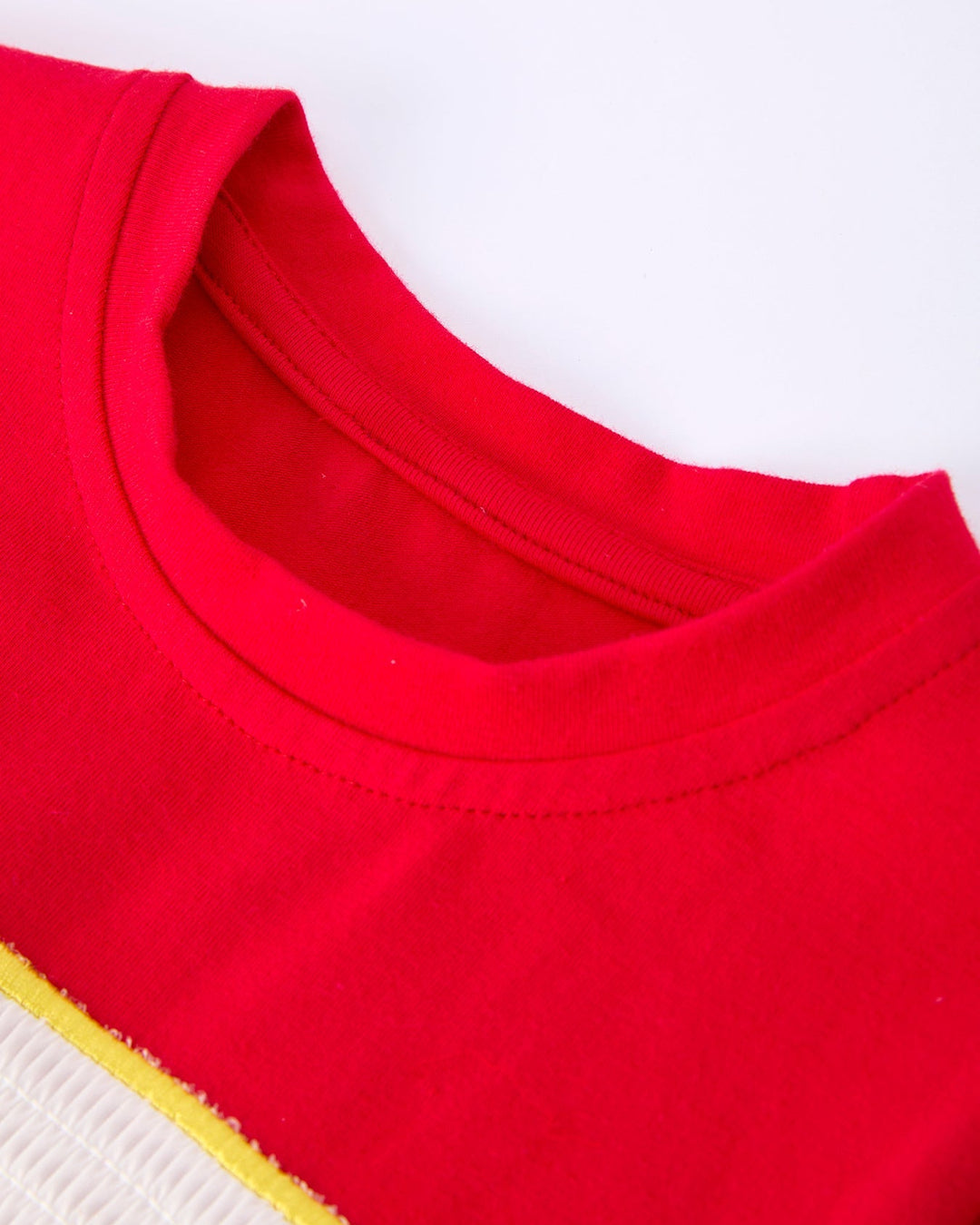 Close-up of a red garment with a yellow trim on a white background