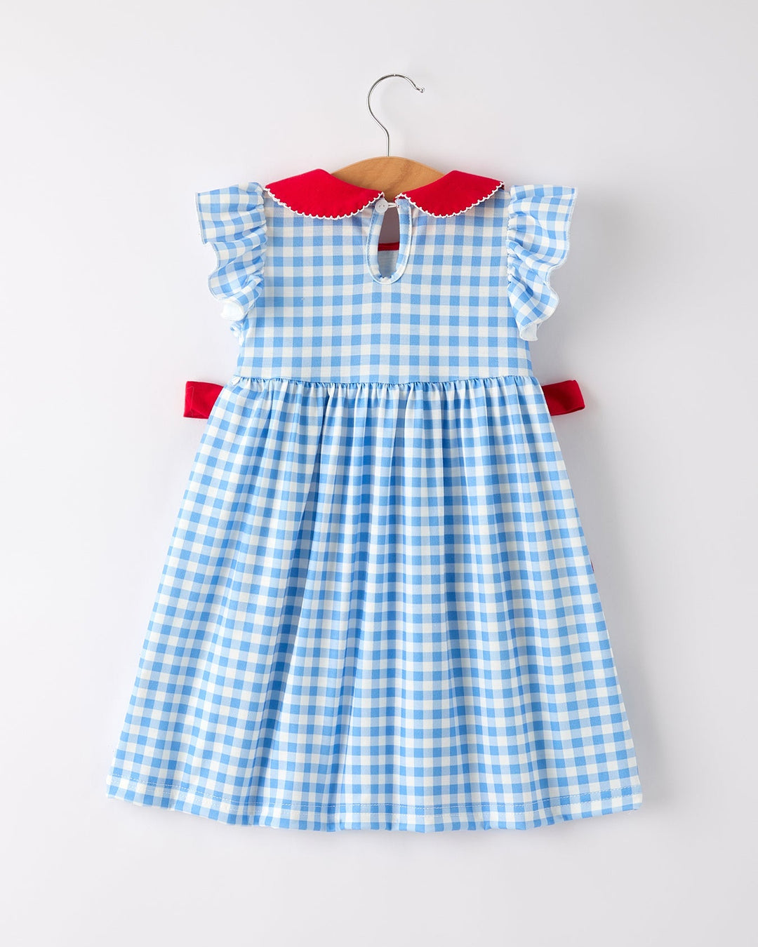 Blue and white checkered dress with red collar and trim on a white background