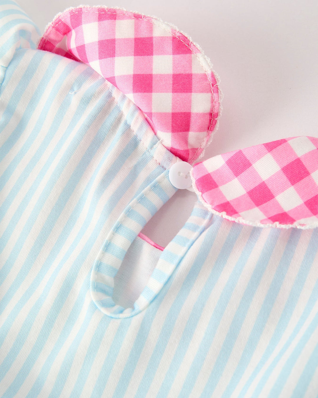 Dress with pink and white checkered design on a blue and white striped background