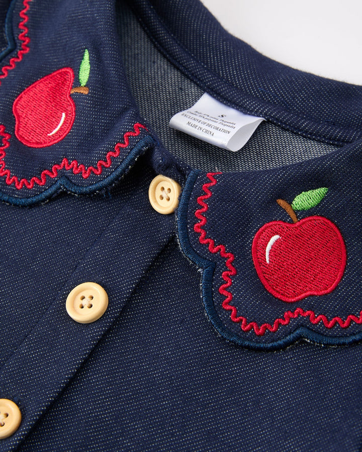 Navy blue fabric with red apple appliqués and beige buttons on a white background