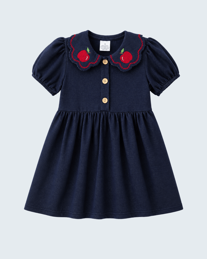 Navy blue dress with red collar and apple details on a light gray background