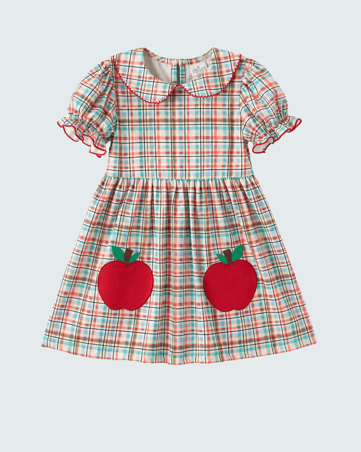 Plaid dress with red apple appliqués on a light gray background