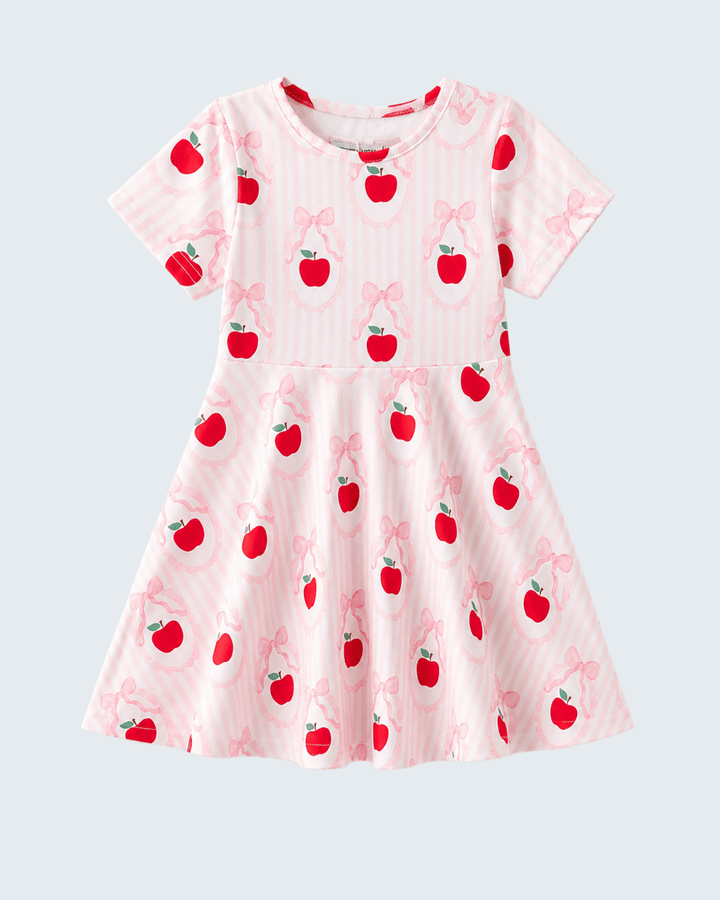 Pink dress with apple and bow pattern on a light gray background