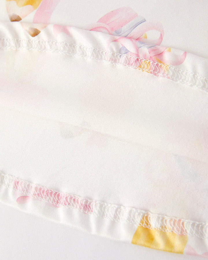 Close-up of a white garment with colorful trim and patterns.