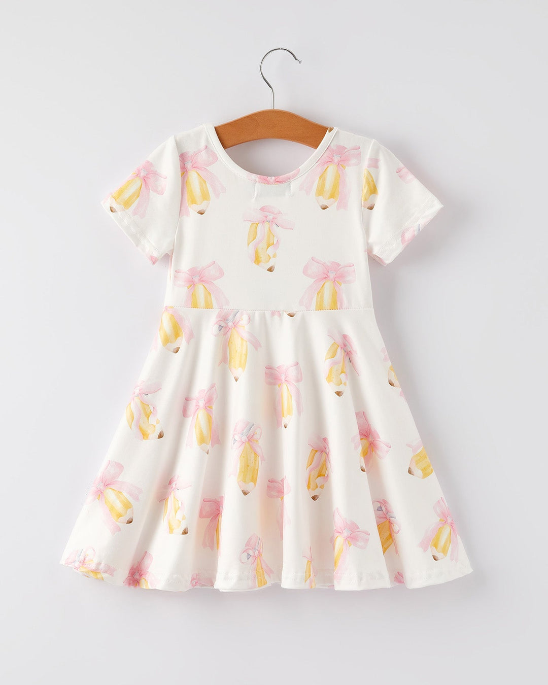 White dress with colorful floral pattern on a hanger against a light gray background