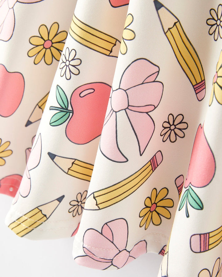 Fabric with school-themed pattern including pencils, apples, and flowers on a white background