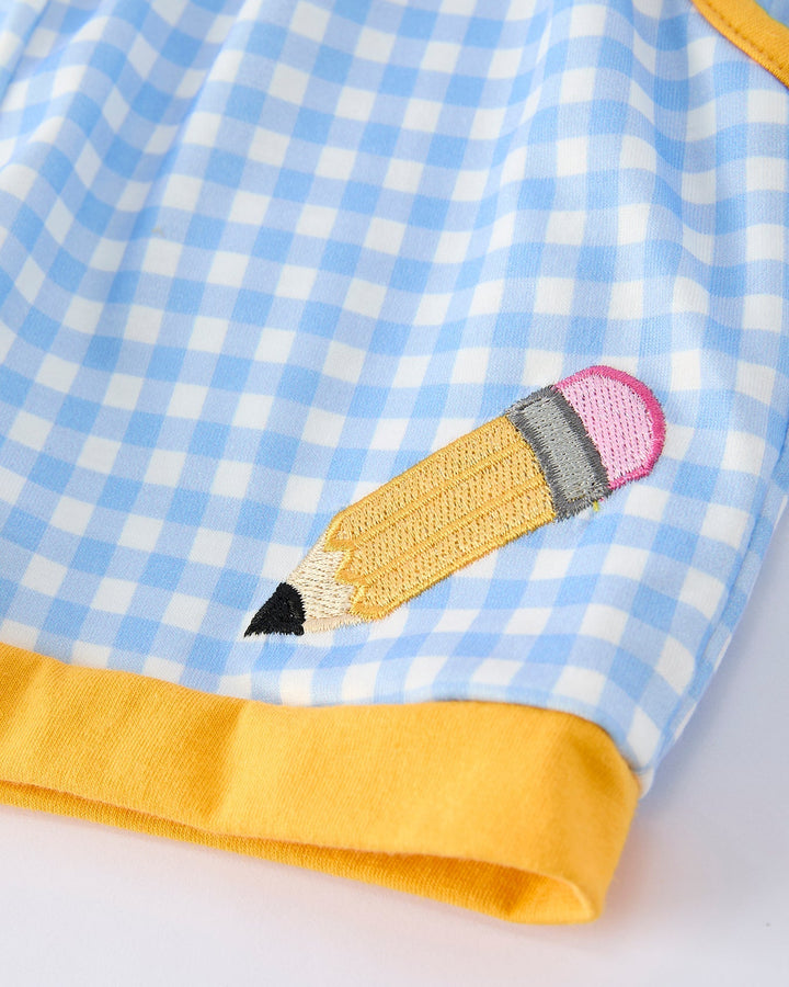 Close-up of a blue checkered fabric with a yellow pencil design on a white background